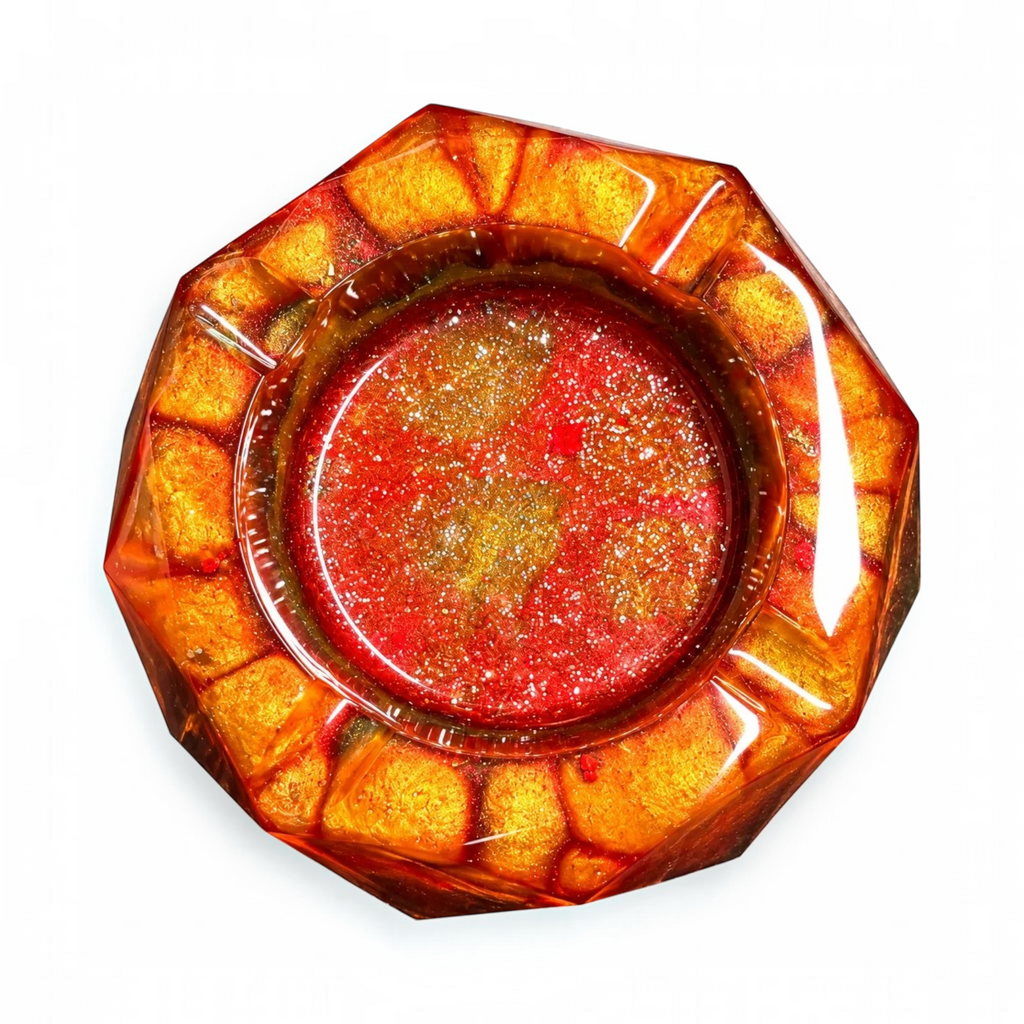 White Ashes Smoke Shop geometric resin ashtray in fiery red, orange, and gold with a shimmering, glossy finish.