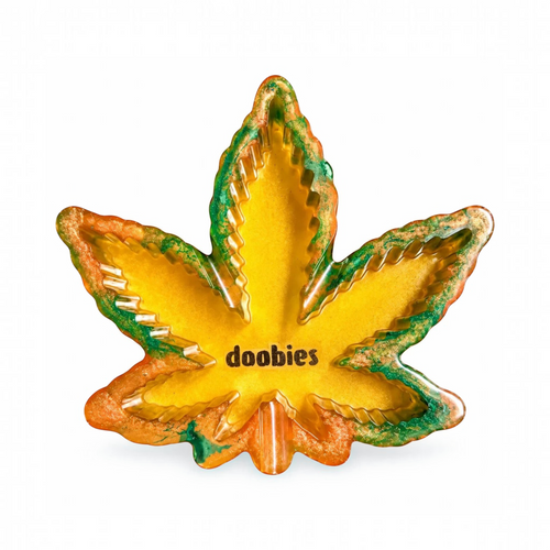 White Ashes Smoke Shop leaf-shaped resin ashtray in vibrant green, orange, and gold with a glossy finish.